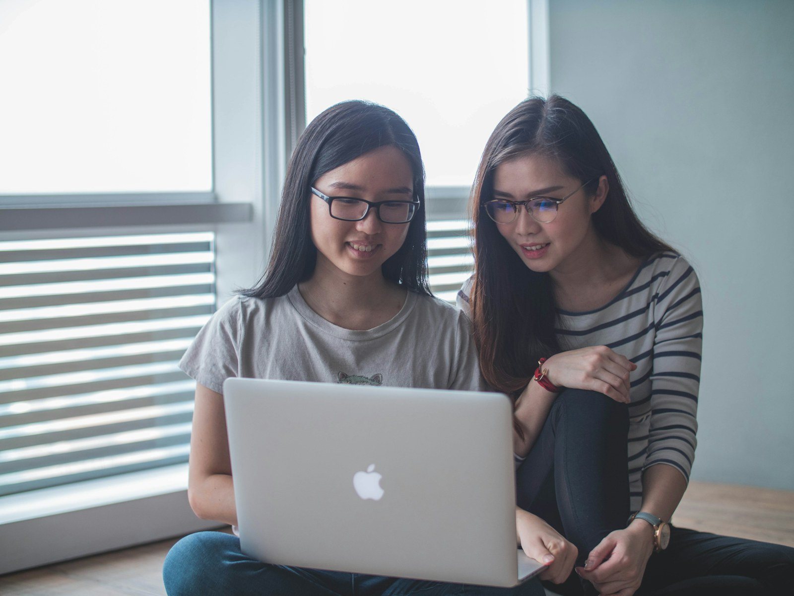 Dos mujeres asiáticas revisan información en un computador portátil